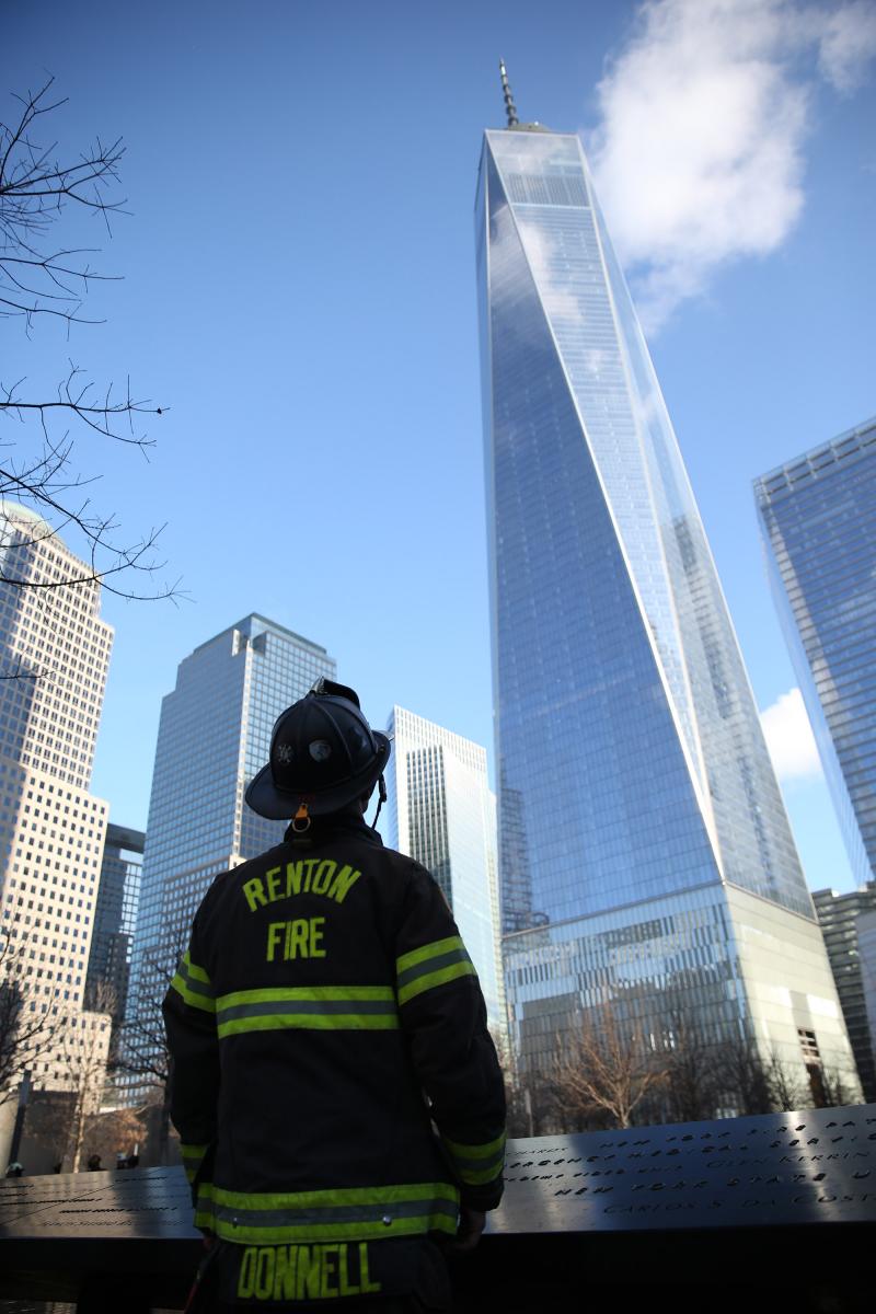 A firefighter pauses in reflection on the 9/11 Memorial plaza. Photo courtesy of InfocusNYC Photography.