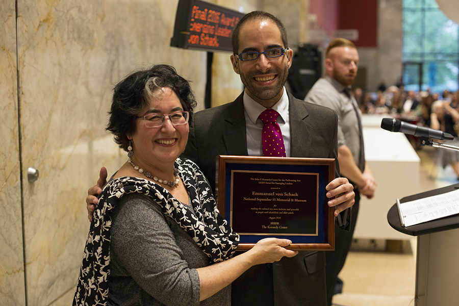 Emmanuel Von Schack and Betty Siegel smile as they hold up an award at the Kennedy Center.