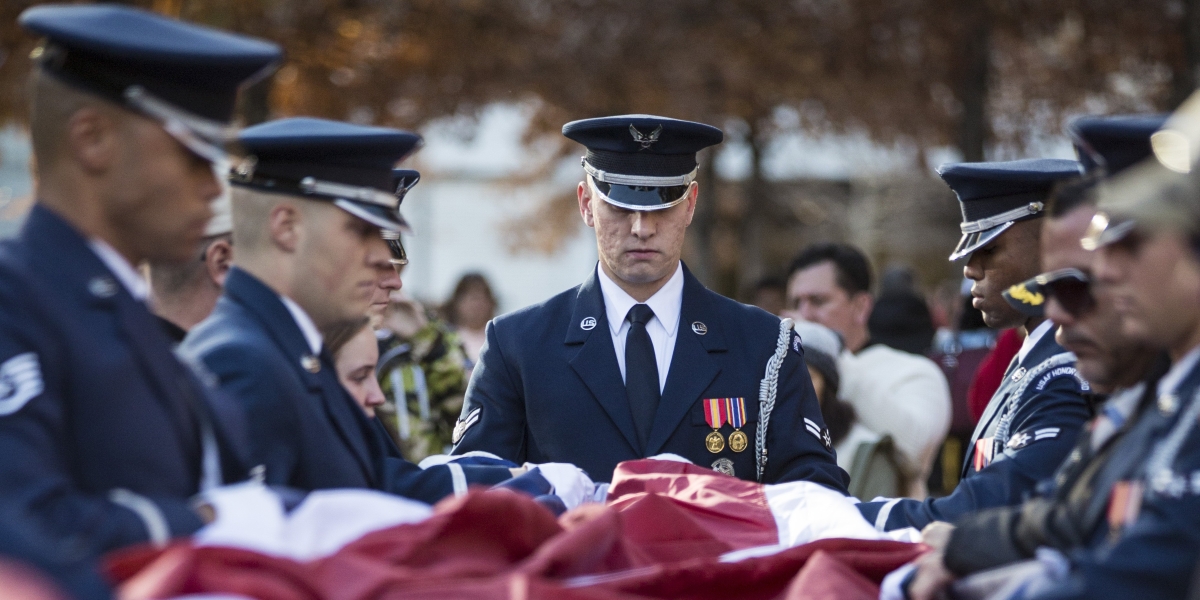 Soldiers fold a flag