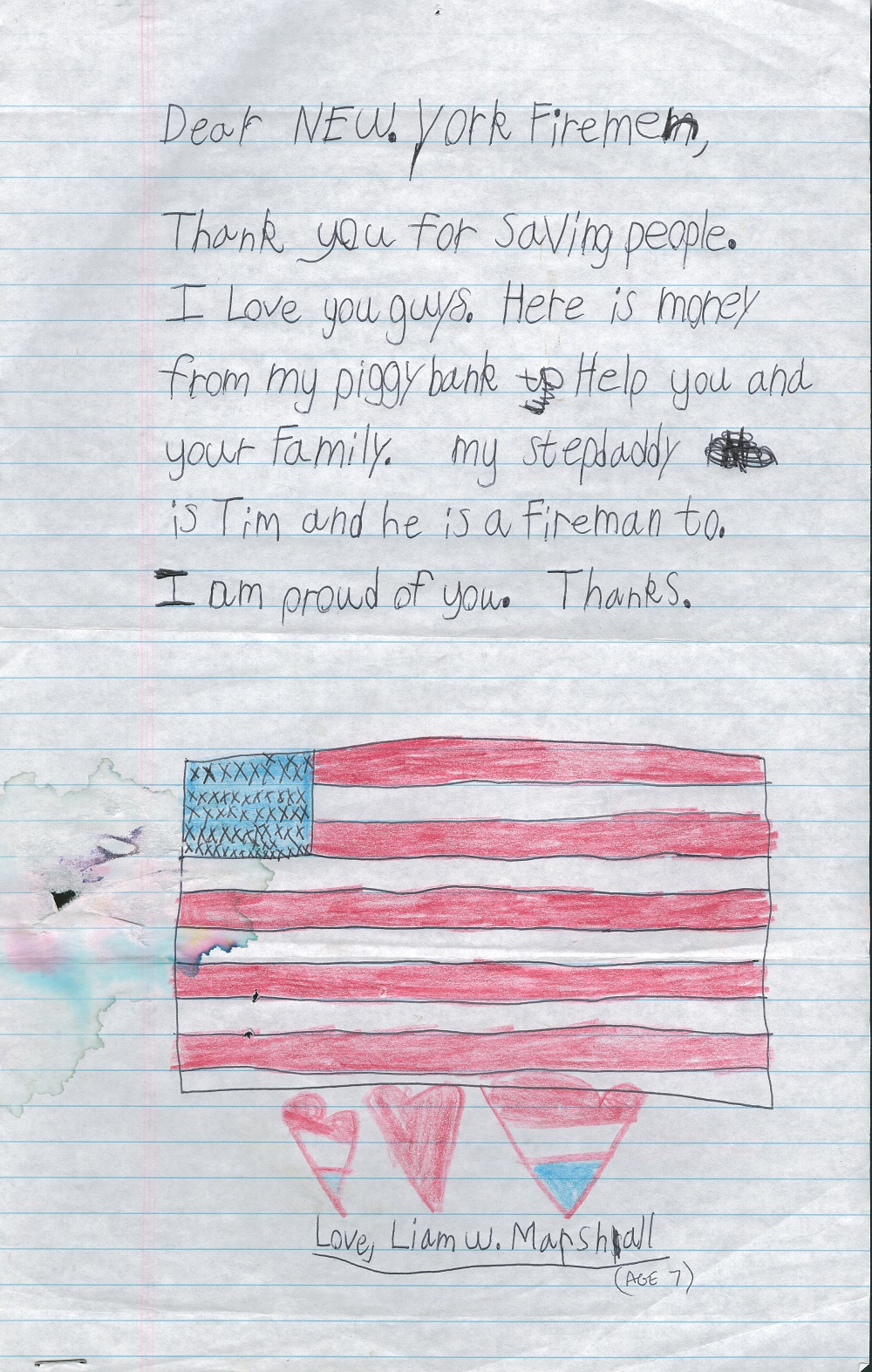 A child’s letter written to New York firefighters includes a message and a drawing of the American flag. Under the flag are three hearts colored red, white, and blue. The message above the flag reads: “Thank you for saving people. I love you guys. Here is money from my piggy bank to help you and your family. My stepdaddy is Tim and he is a fireman too. I am proud of you. Thanks.”