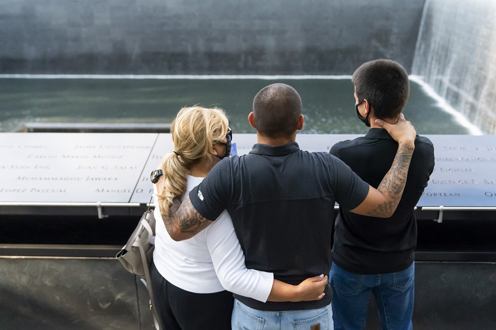 A family embraces on the Memorial plaza.
