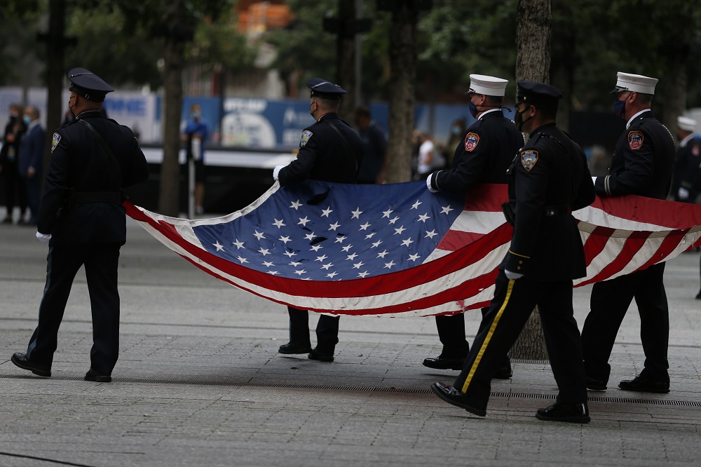 A color guard procession brings the American flag to the 9/11 Memorial plaza.