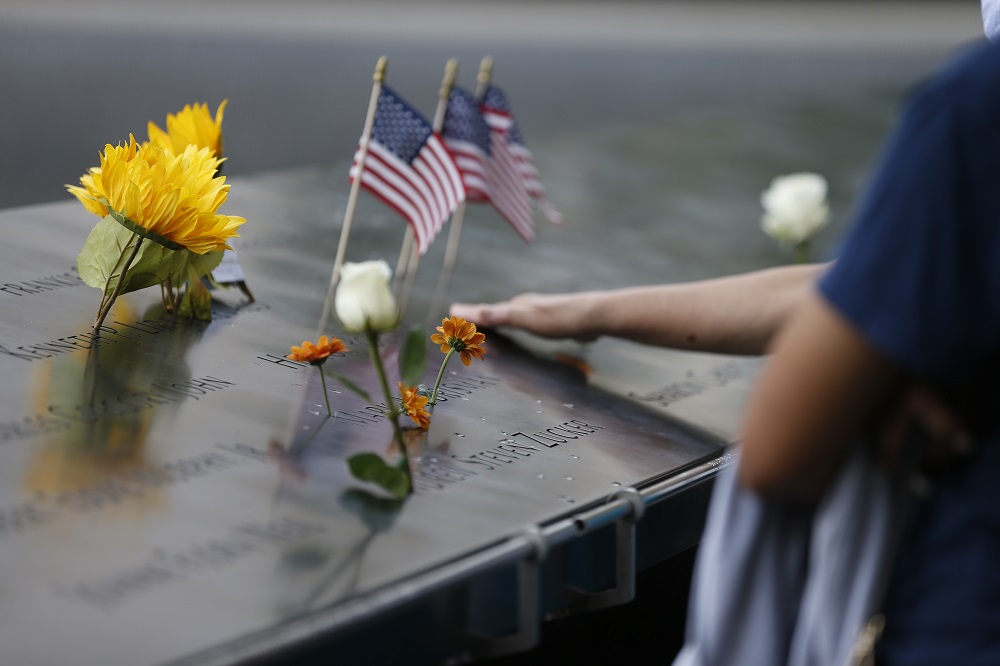 Flower tributes and an American flag are left on the memorial.