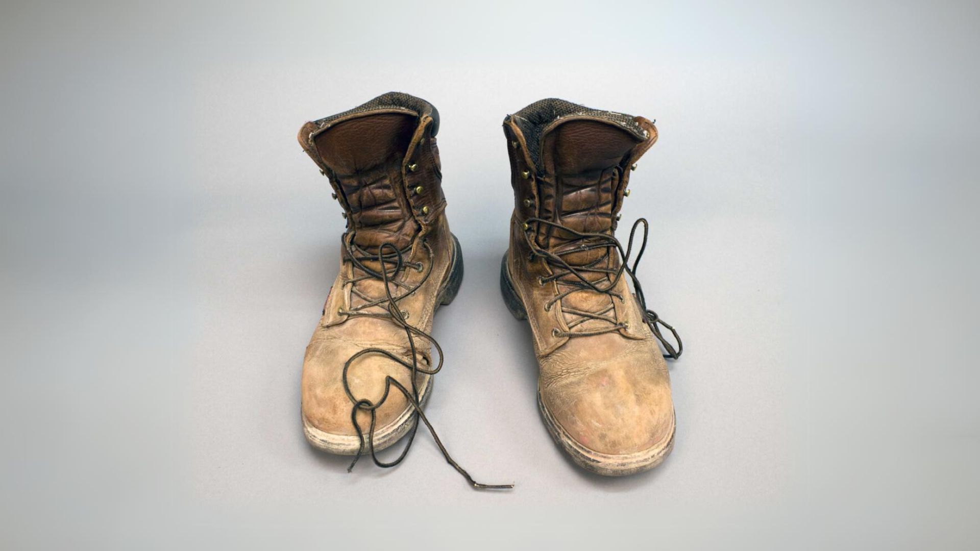 A pair of work boots with visible damage.
