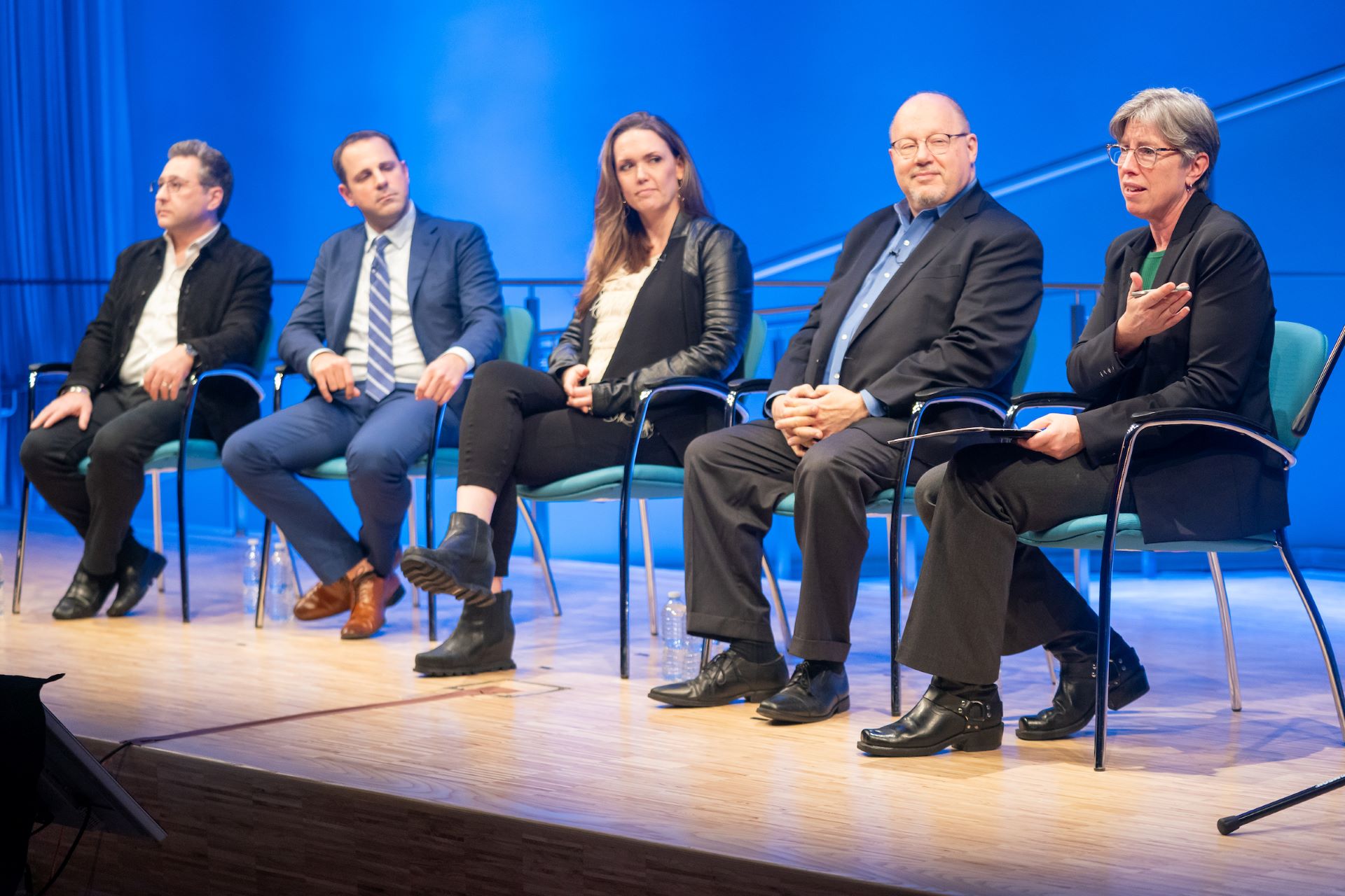 Panelists sit on stage with with Dr. Beth Hillman, President and CEO of the 9/11 Memorial and Museum, side view