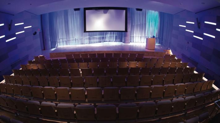 Auditorium facing stage with seats visible from AV room in back
