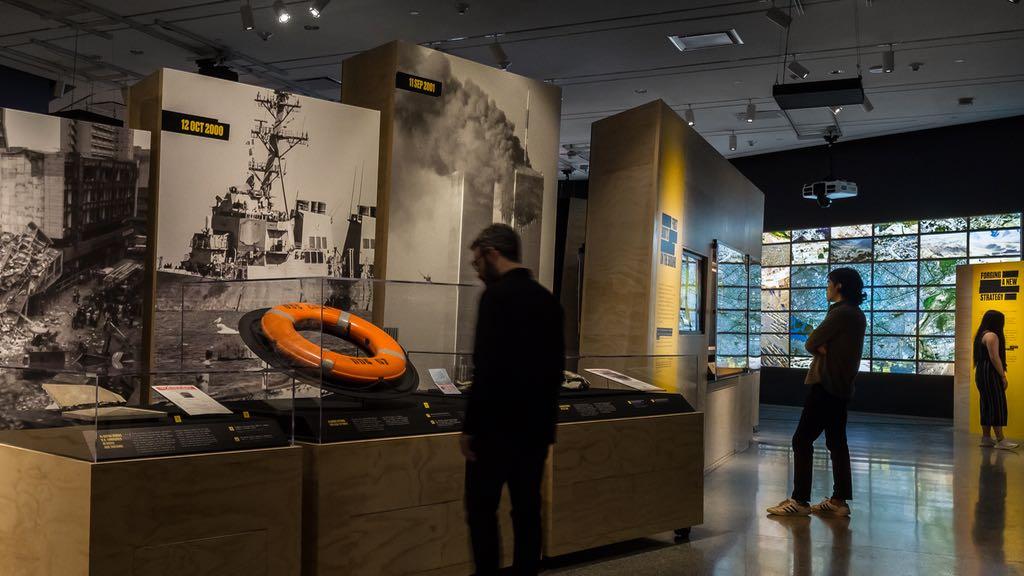 Two individuals observing installations in a gallery space.