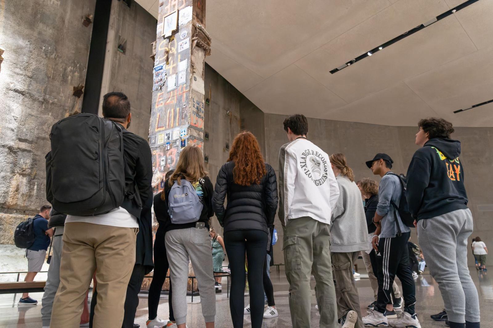 Students stand around a large artifact