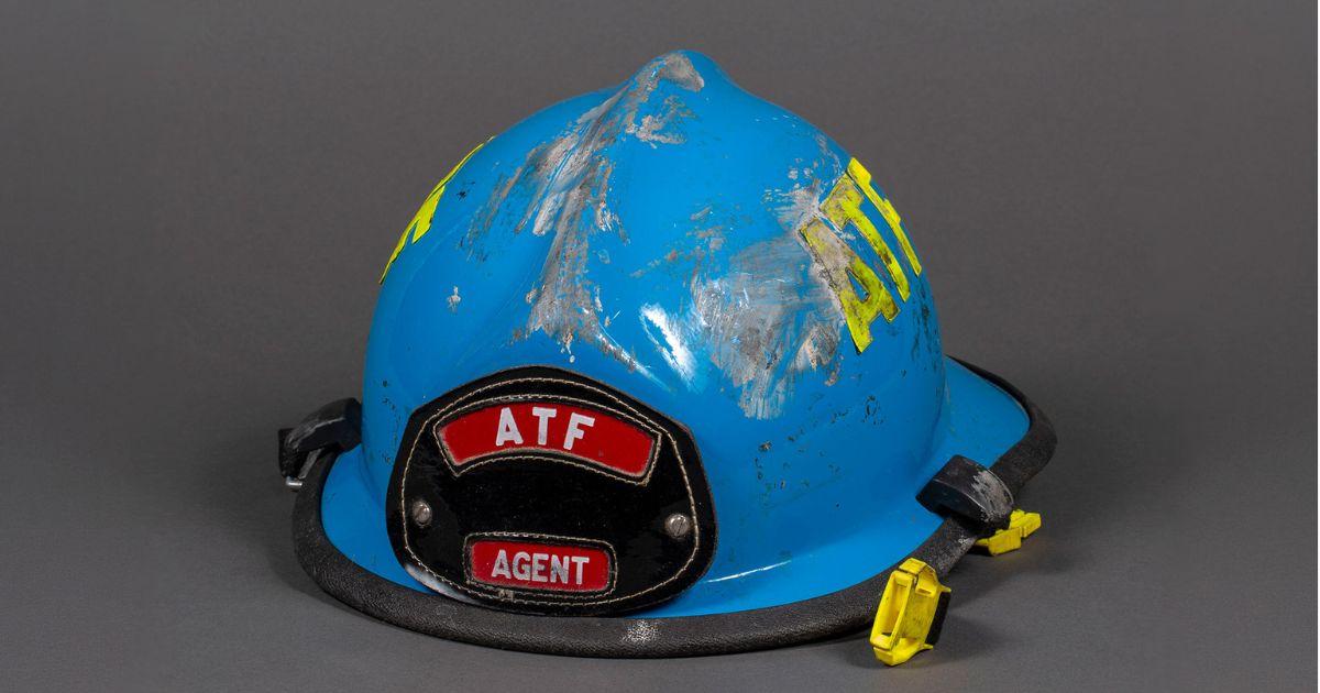 A battered blue and yellow construction hat that reads ATF Agent at the front.