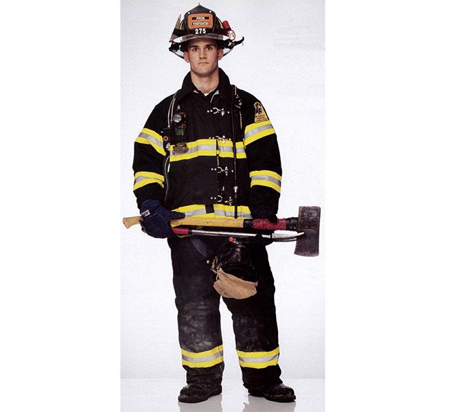 Firefighter Jason Cascone holds an axe as he poses in his bunker gear for the Faces of Ground Zero.