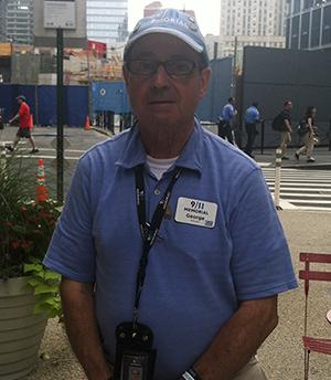 George Mironis poses for a photo at the entrance to the 9/11 Memorial on a cloudy day.