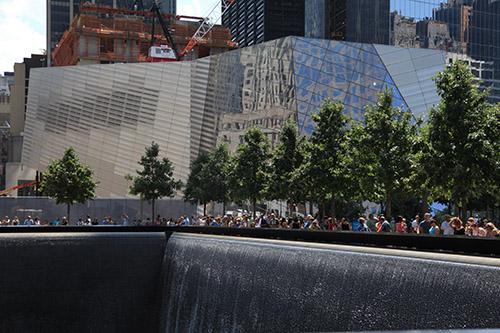 The Museum pavilion is seen from across the north reflecting pool on a sunny day at Memorial plaza.