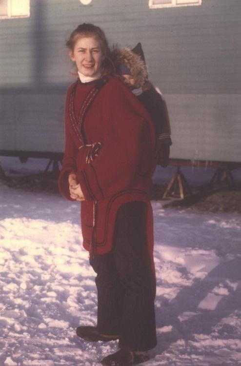 Christine Egan, who worked as a nurse, is seen wearing an indigenous outfit and carrying a small child in the snow-covered Nunavut territory of Canada.