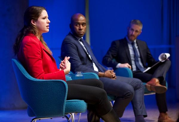 Dr. Muhammad Fraser-Rahim and Katherine Zimmerman sit onstage as they take part in a public program in the Museum auditorium. Noah Rauch, the senior vice president of Education and Public Programs, sits with a clipboard to the right.