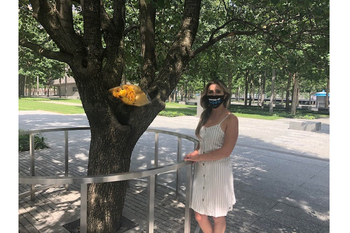 Caitlin Leavey, whose father died in the 9/11 attacks, poses for a photo beside the Survivor Tree at Memorial plaza.